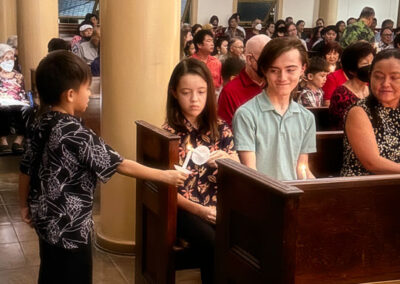 People sitting and a boy holding candle at Makiki-Christian-Church-chapel Christmas eve 2024