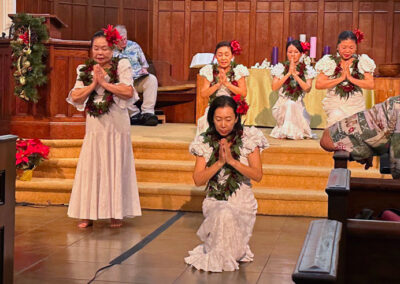 Ladies dancing with white dress red flower on their head and leaves lei at Makiki-Christian-Church-chapel Christmas eve 2024