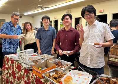 Makiki Christian Church Christmas eve dinner 2024 People smiling and holding food